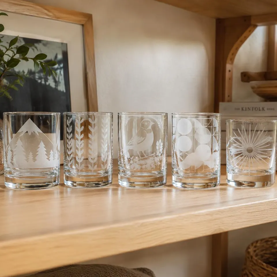 Række af sandblæste glas med natur- og mønstermotiver